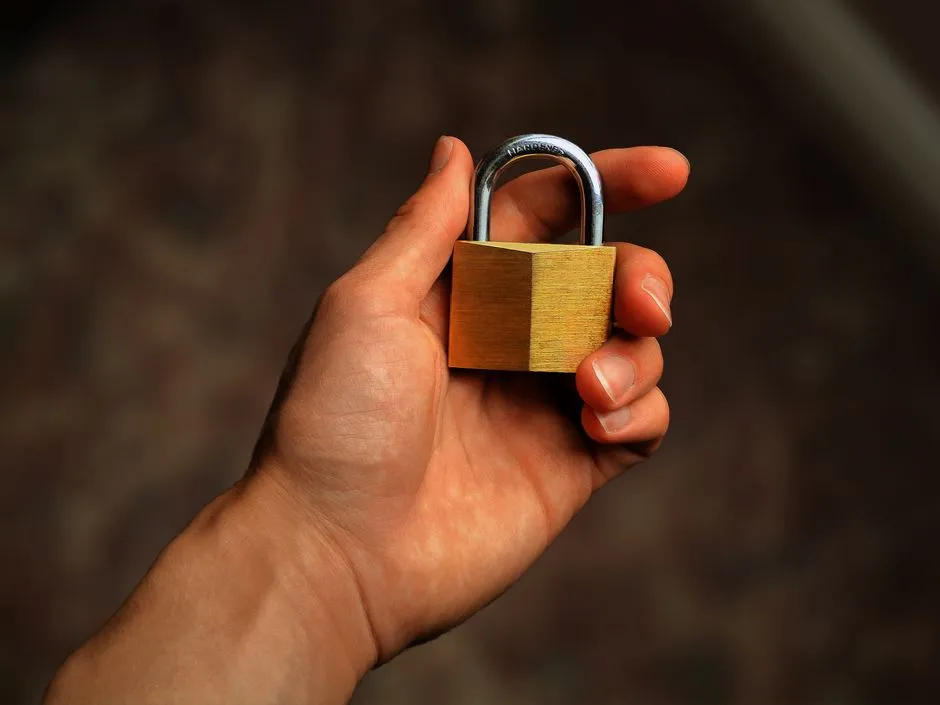 A hand holding a padlock, symbolizing account security