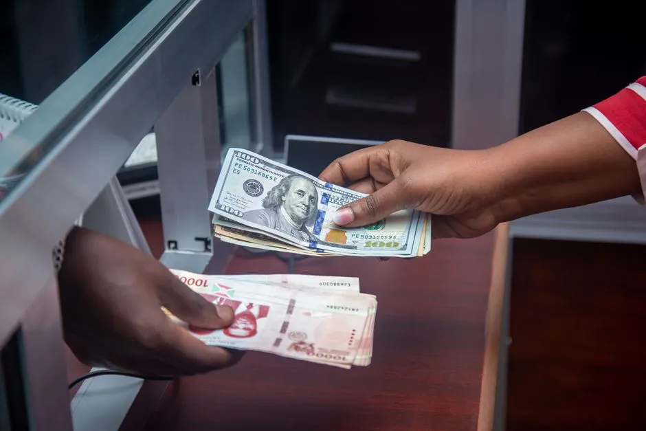 Two people exchanging cash by hand, illustrating a money transfer